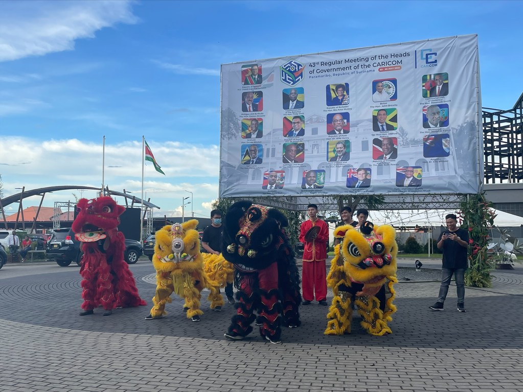 گروهی از چینی-سورینامی ها در حالی که سران کشورها و دولت ها به چهل و سومین کنفرانس CARICOM در پاراماریبو، سورینام می آیند، می رقصند و می خوانند.
