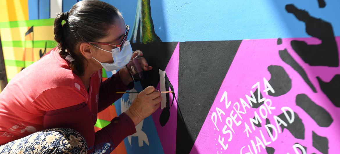 زنی نقاشی دیواری برای صلح و آشتی در کلمبیا می کشد.
