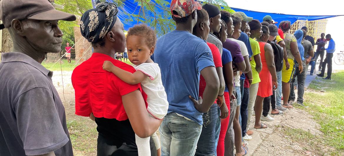 مردم برای دریافت بسته های بهداشتی در Les Cayes در جنوب غربی هائیتی صف می کشند.