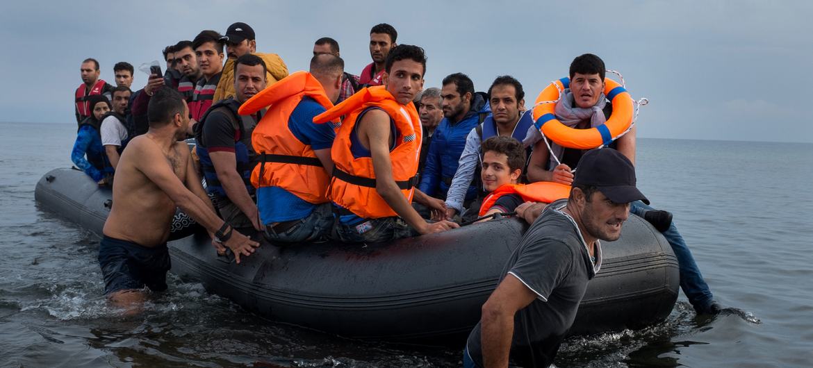 یک قایق لاستیکی بزرگ پر از پناهجویان به ساحل جزیره لسبوس در منطقه دریای اژه شمالی کشیده می شود.  (فایل)