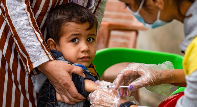 یک کودک در 26 اکتبر 2022 واکسن را در محله غویران، شهر حسکه، شمال شرق سوریه از یک کارمند وزارت بهداشت دریافت کرد.